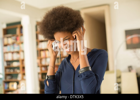 Frau hören Kopfhörer im Wohnzimmer Stockfoto