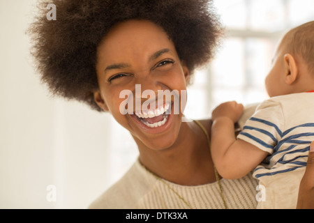 Lachende Mutter hält Baby boy Stockfoto