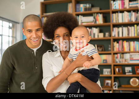 Familie lächelnd zusammen im Wohnzimmer Stockfoto