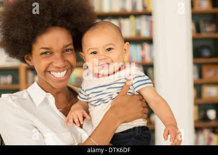 Mutter hält Baby Boy im Wohnzimmer Stockfoto