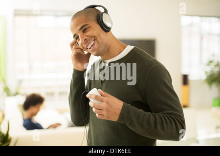 Kopfhörer im Wohnzimmer hören Mann Stockfoto