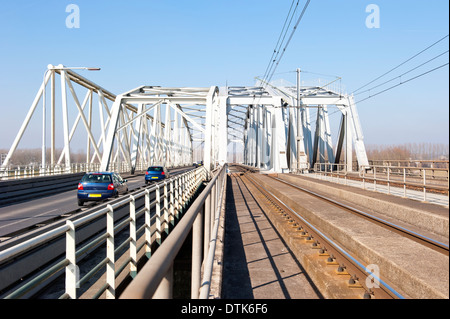 Historischen holländischen Brücke mit getrennten Eisenbahn und Auto Fahrspuren überqueren den Fluss IJssel bei der Stadt Westervoort, Niederlande. Stockfoto