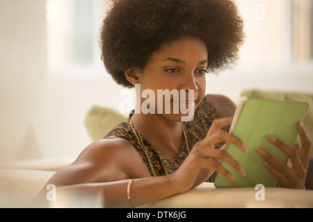 Frau mit digital-Tablette auf sofa Stockfoto