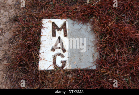 Weiß MAG oder Mines Advisory Group Marker Backstein mit einer sicheren Gegend in Plain of Jars in Laos Stockfoto