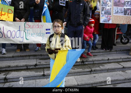 Dublin, Irland. 19. Februar 2014. Eine Mädchen steht vor den Demonstranten mit einer ukrainischen Flagge. Ukrainische Staatsbürger leben in Irland, die außerhalb des EU-Büros in Dublin gegen die Gewalt der Regierung in Kiew protestiert. Sie forderten die EU Sanktionen gegen die Ukraine, um die Gewalt zu stoppen. Bildnachweis: Michael Debets/Alamy Live-Nachrichten Stockfoto