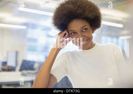 Geschäftsfrau, die lächelnd im Büro Stockfoto