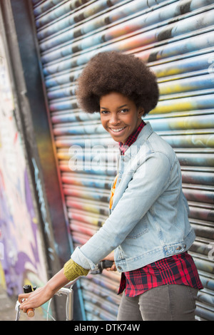 Frau mit Fahrrad vor Graffitiwand Stockfoto