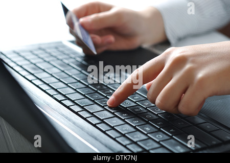 Weibliche Hände mit Laptop-Tastatur und Holding-Kreditkarte für Online-shopping Stockfoto