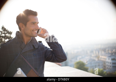 Geschäftsmann am Handy mit Blick auf Stadt Stockfoto