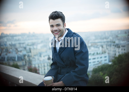 Geschäftsmann, trinken Kaffee auf Felsvorsprung über Paris, Frankreich Stockfoto