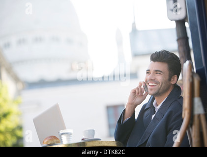 Geschäftsmann, reden über Handy im Straßencafé in der Nähe von Sacre Coeur Basilika, Paris, Frankreich Stockfoto