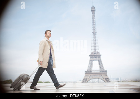 Geschäftsmann ziehen Koffer in der Nähe von Eiffelturm, Paris, Frankreich Stockfoto