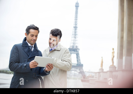 Geschäftsleute, die mit digital-Tablette in der Nähe von Eiffelturm, Paris, Frankreich Stockfoto