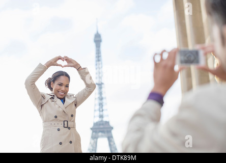 Mann fotografiert Freundin vor Eiffelturm, Paris, Frankreich Stockfoto