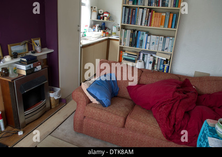 Plattenbauten an der Themse entlang überflutet. View Form innerhalb des Hauses in der Zeit nach dem Hochwasser. Wohnzimmer mit behelfsmäßigen Bett, Sofa und Kamin. Stockfoto