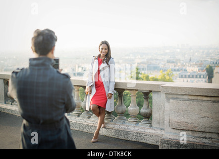 Freund fotografieren Freundin mit Paris im Hintergrund Stockfoto