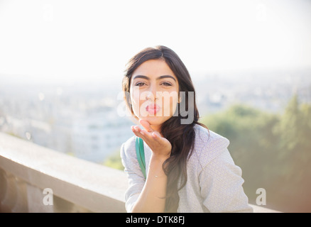 Frau bläst einen Kuss im freien Stockfoto