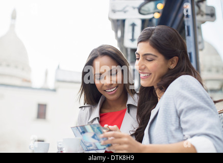 Frauen lesen Postkarte im Straßencafe in Paris, Frankreich Stockfoto