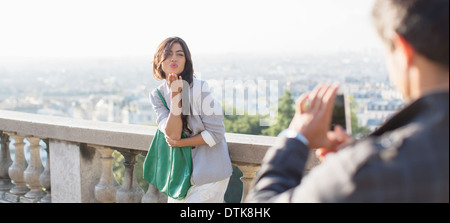 Mann fotografiert Freundin mit Paris im Hintergrund Stockfoto