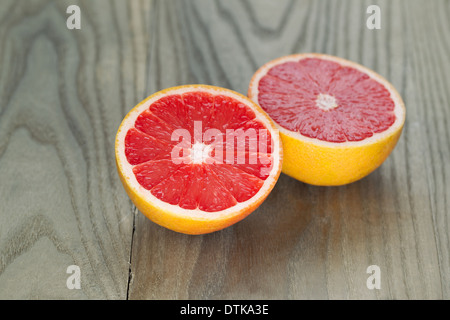 Horizontale Foto von geschnittenen Rubin rote Grapefruit auf Alter Holz Stockfoto