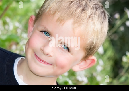 Young Boy im Garten mit einem Grinsen auf seinem Gesicht Stockfoto