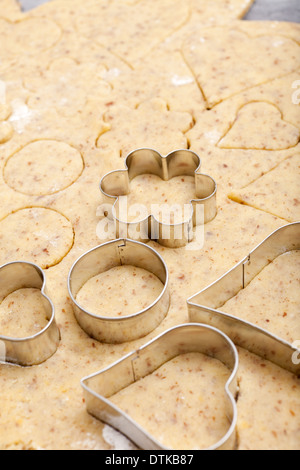 Ausstecher in verschiedenen Formen liegen auf Cookie-Teig mit textfreiraum im oberen Bereich Stockfoto