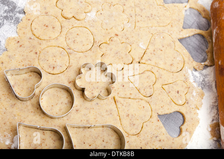 Ausstecher in verschiedenen Formen liegen auf Cookie-Teig mit textfreiraum im oberen Bereich Stockfoto