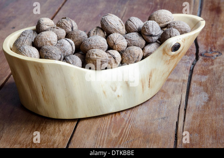 schönen Holzschale voller Walnüsse auf dem Vintage Holztisch mit Fokus auf Muttern Stockfoto