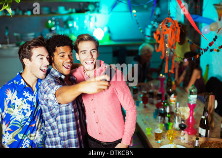 Männer, die Selbstporträts mit Kamera-Handy auf party Stockfoto