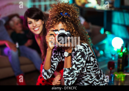 Frau mit Kamera im Wohnzimmer auf party Stockfoto