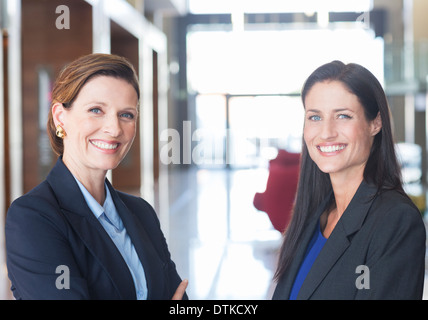 Geschäftsfrauen, die lächelnd in lobby Stockfoto