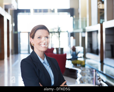 Geschäftsfrau, die lächelnd in lobby Stockfoto