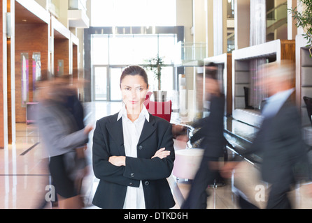 Geschäftsfrau im belebten Lobby stehen Stockfoto