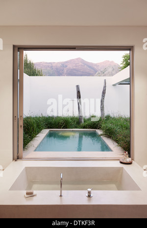 Modernes Bad mit Blick auf Pool und Berge Stockfoto