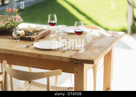 Wein und Aperitif auf hölzernen Esstisch auf der Terrasse Stockfoto