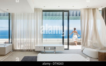 Frau auf modernen Balkon mit Blick auf Meer Stockfoto