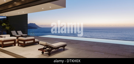 Moderne Terrasse und Infinity-Pool mit Blick auf Meer bei Sonnenuntergang Stockfoto
