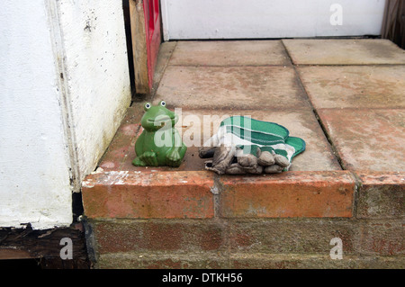 Plattenbauten an der Themse entlang überflutet. Garten Handschuhe und Zierpflanzen Frosch auf der Veranda Landung außerhalb. Stockfoto