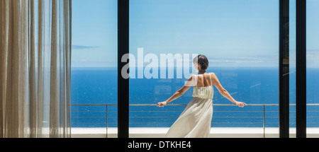 Frau, die am Meer vom Balkon Stockfoto