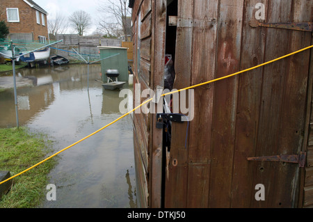 Plattenbauten an der Themse entlang überflutet. Elektrische Verlängerungskabel für Fenster und Tür angebracht, um im Garten zu werfen. Stockfoto