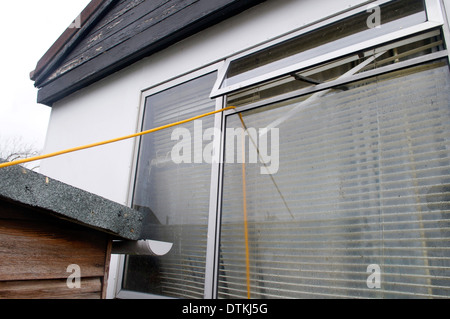 Plattenbauten an der Themse entlang überflutet. Elektrische Verlängerungskabel für Fenster und Tür angebracht, um im Garten zu werfen. Stockfoto