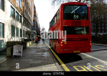 Rot-London-Bus nähert sich eine Bushaltestelle am Russel Square, London Stockfoto