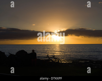 Einer der vielen schönen goldenen Sonnenuntergänge in Playa de Las Americas Teneriffa Kanaren Spanien, Silhouette der Touristen auf der promenade Stockfoto