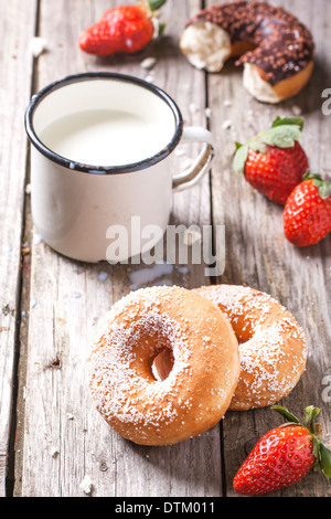 Zucker Donuts und frischen Erdbeeren und Vintage Becher Milch auf Holztisch serviert. Serien ansehen Stockfoto