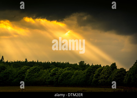 Sonnenstrahlen, die durch stürmischen Wolken Stockfoto