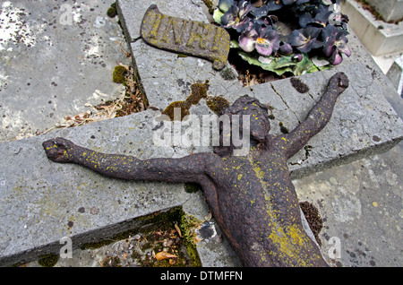 Eine vernachlässigte, Zeit verwitterten Grab mit einer rostigen Figur Jesu im Friedhof Montmartre in Paris Frankreich. Stockfoto