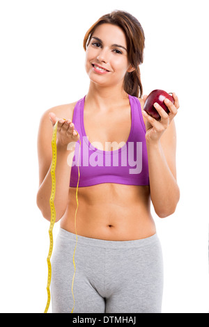 Schöne und gesunde Frau hält einen Apfel und ein Maßband, isoliert auf weißem Hintergrund Stockfoto