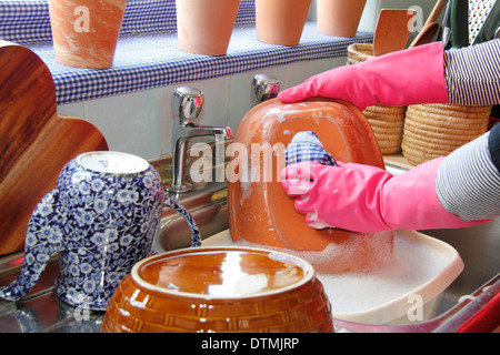 Frau trägt Gummihandschuhe die Töpfe in der Küche abwaschen sinken zu Hause Stockfoto