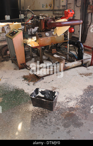 Ein Diesel Kraftstoff auslaufen in einem Kesselhaus mit Saugeinlagen und Granulat aufsaugen und enthält das Auslaufen Stockfoto