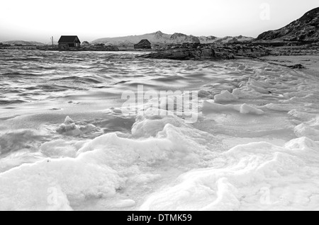 Ein Bootshaus auf einem gefrorenen Strand am Sommaroy, Norwegen Stockfoto